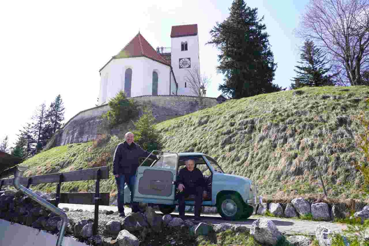 Ausfahrt im Goggomobil auf den Auerberg: Werner Maier mit dem Mesner-Jubilar Herbert Stechele (auf dem Beifahrersitz) unter der Georgikirche. Foto: Johannes Jais