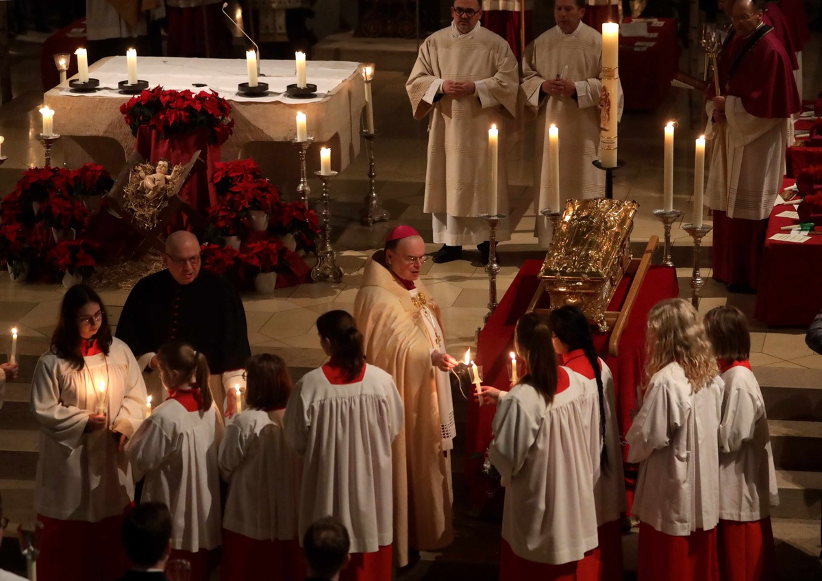 Bischof Bertram zündet die Kerzen der Ministranten an, bevor der Ulrichsschrein in einer Lichterprozession von der Ulrichsbasilika zum Augsburger Dom getragen wird. (Fotos: Annette Zoepf)