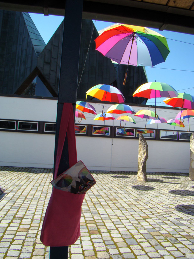 In bunten Regenbogenfarben leuchten noch bis zum Schulstart 24 Schirme im Innenhof des Pfarrzentrums in Landsberg. Die Botschaft – von Gott gut beschirmt und beschützt zu sein – soll den Menschen während der Sommerwochen  mit auf den Weg gegeben werden.  Foto: Rabl  