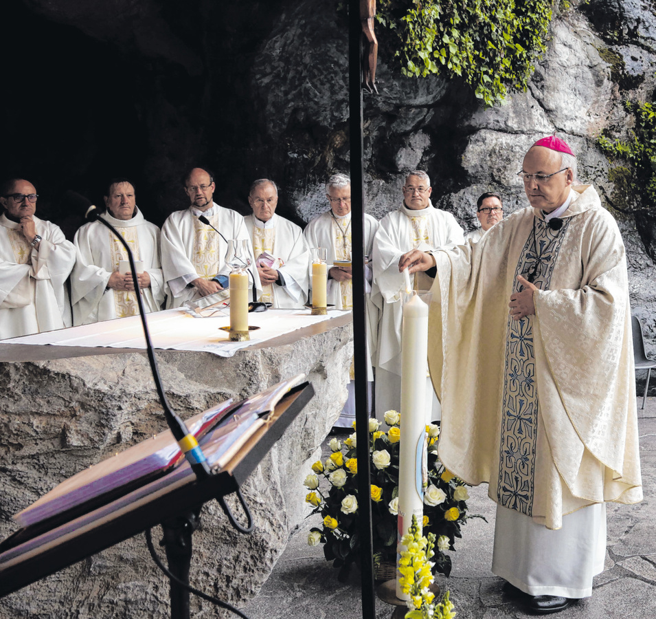 Bischof Rudolf Voderholzer entzündet die Anliegenkerze des Bistums an der Erscheinungsgrotte in Lourdes.