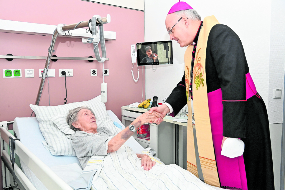 An den Krankenbetten nahm sich Bischof Rudolf nicht nur Zeit zum persönlichen Gespräch mit den Patientinnen und Patienten, sondern auch zum gemeinsamen Beten und für Segensworte. Foto: Hans-Christian Wagner