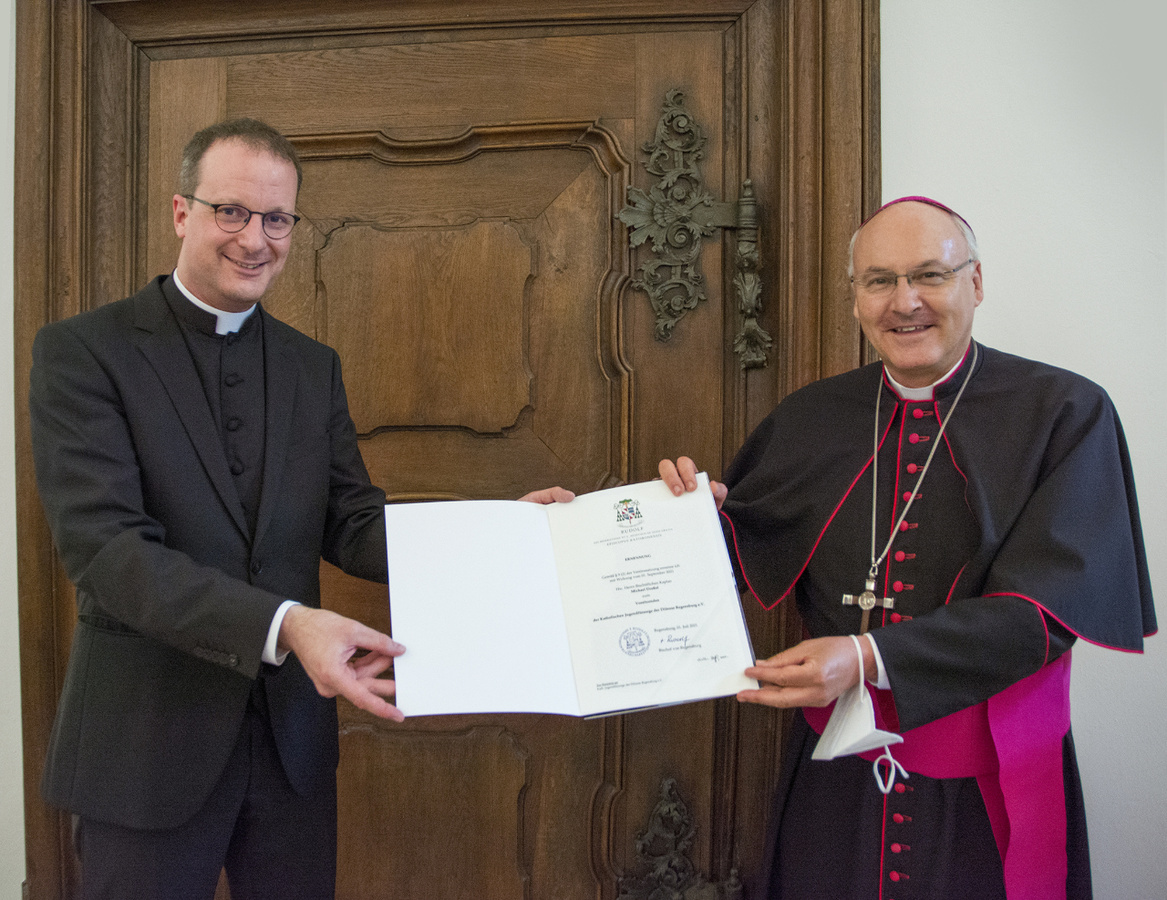 Bischof Rudolf Voderholzer übergibt Michael Dreßel die Ernennungsurkunde.
