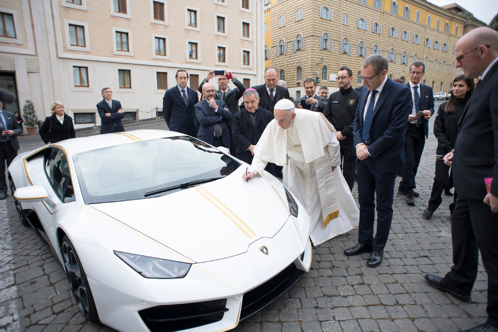 Papst Franziskus unterschreibt auf dem weißen Lamborghini, der nun für einen guten Zweck versteigert wurde. (Foto: KNA)