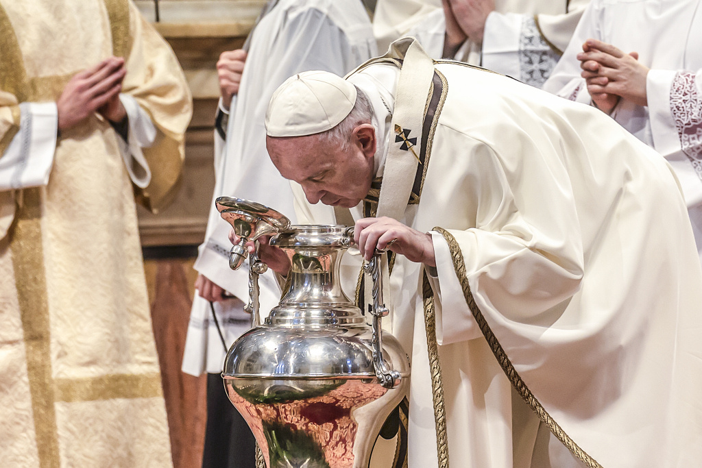 Papst Franziskus beugt sich über einen Behälter mit Chrisamöl. (Foto: KNA)