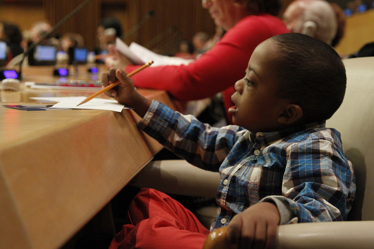 Ein afrikanisches Kind mit Downsyndrom bei einer Konferenz der Vereinten Nationen. In manchen Ländern des „Schwarzen Kontinents“ gelten Trisomie-21-Betroffene als Geisteskranke. Oder man führt die Genmutation auf den Einfluss von Hexerei zurück. (Foto: UN Photo/Paulo Filgueiras)