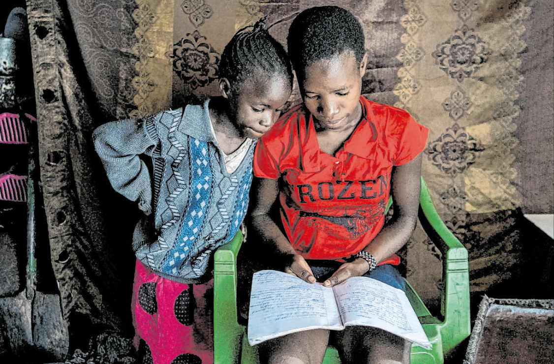 Die 15-jährige Kenianerin Sarah ist durch die Auswirkungen der Corona-Pandemie gezwungen, zu Hause zu lernen. Nebenher unterrichtet sie noch ihre kleine Schwester. (Foto: Unicef/Alissa Everett)