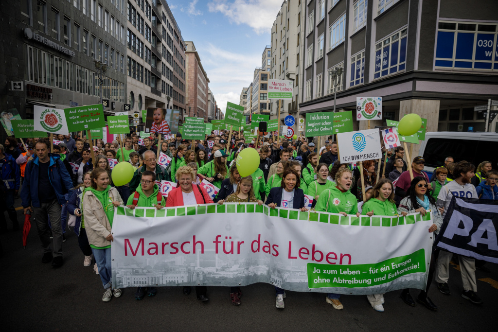 Demonstranten stehen hinter einem großen Banner mit der Aufschrift "Marsch für das Leben. Ja zum Leben - Für ein Europa gegen Abtreibung und Euthanasie!" Sie halten grüne Luftballons, Holzkreuze und Schilder mit verschiedenen Aufschriften beim "Marsch für das Leben" gegen Abtreibung und aktive Sterbehilfe am 17. September 2022 in Berlin. (Foto: KNA)