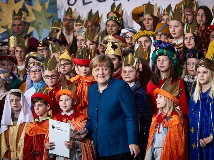 Bundeskanzlerin Angela Merkel steht lachend am 7. Januar 2020 im Bundeskanzleramt in Berlin inmitten von Sternsingern aus allen deutschen Bistümern. (Foto: KNA)