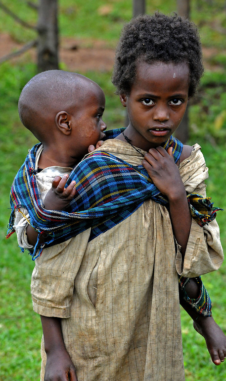 Ein kenianisches Mädchen trägt ein kleines Kind auf dem Rücken. (Foto: KNA)