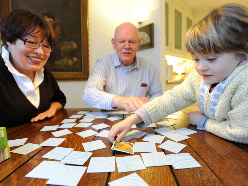 Ein Mädchen spielt mit den Großeltern Memory. (Foto: KNA)