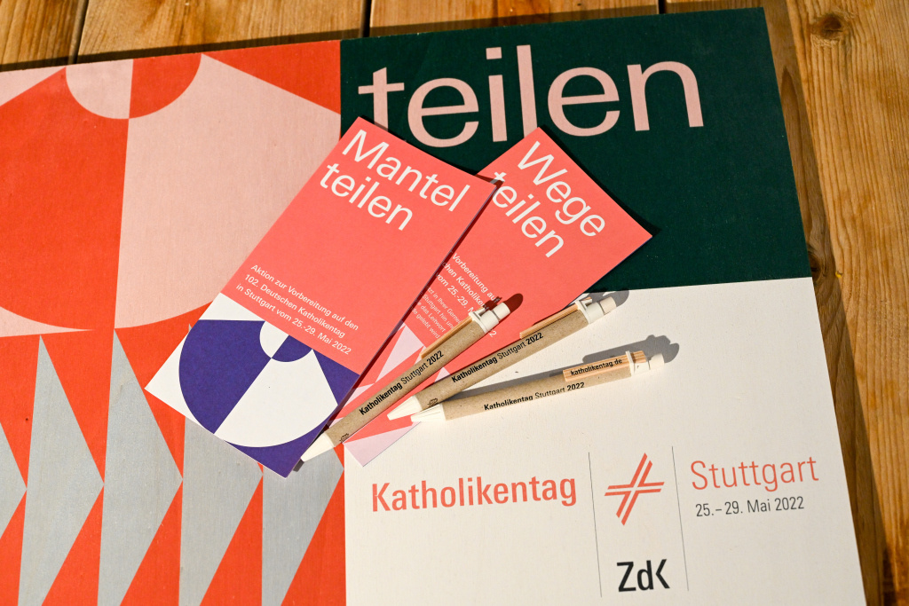 Informationsblätter und Kugelschreiber liegen auf einem Logo des 102. Deutschen Katholikentags 2022 am 29. September 2021 auf einem Tisch in Stuttgart. (Foto: KNA)