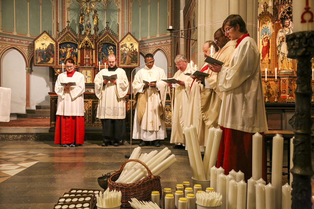 Priester und Messdiener singen aus dem Gotteslob beim Gottesdienst an Mariä Lichtmess in der Kirche Sankt Maria Magdalena in Bonn. Vor dem Altar stehen Kerzen zur Segnung bereit. (Archivfoto: KNA)