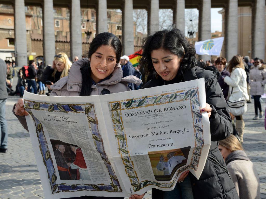 Gläubige lesen am 17. März 2013 in der Sonderausgabe des Osservatore Romano zur Wahl von Papst Franziskus. (Foto: KNA)