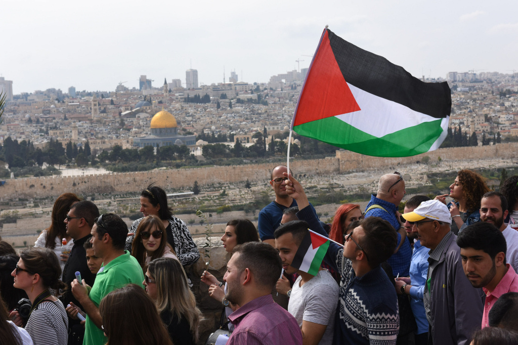 Ein Mann schwingt die palästinensische Flagge am 9. April 2017 in Jerusalem. Im Hintergrund ist die goldene Kuppel des Felsendoms zu sehen. (Foto: KNA)