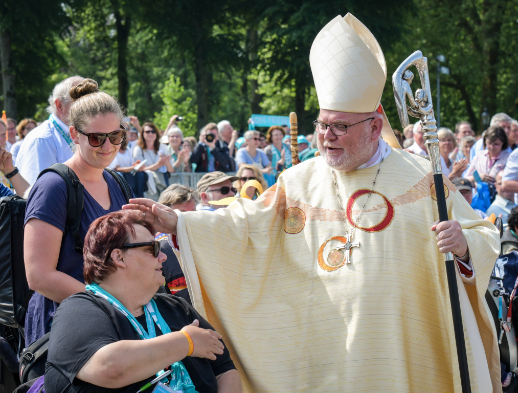 Kardinal Reinhard Marx segnet beim Abschlussgottesdienst des Katholikentags eine Teilnehmerin im Rollstuhl. (Foto: KNA)