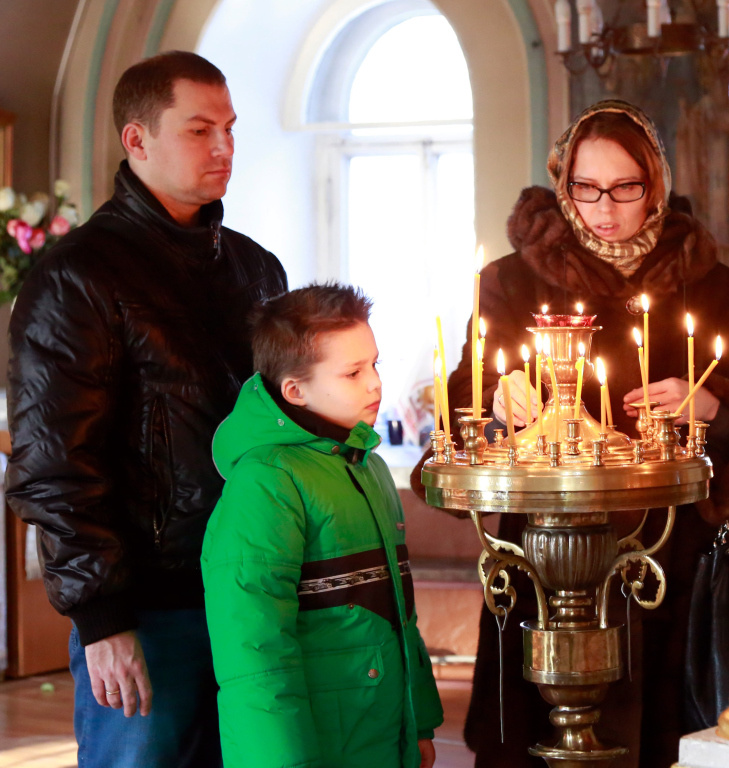 Eine orthodoxe Familie entzündet zu Weihnachten eine Kerze. (Foto: KNA)