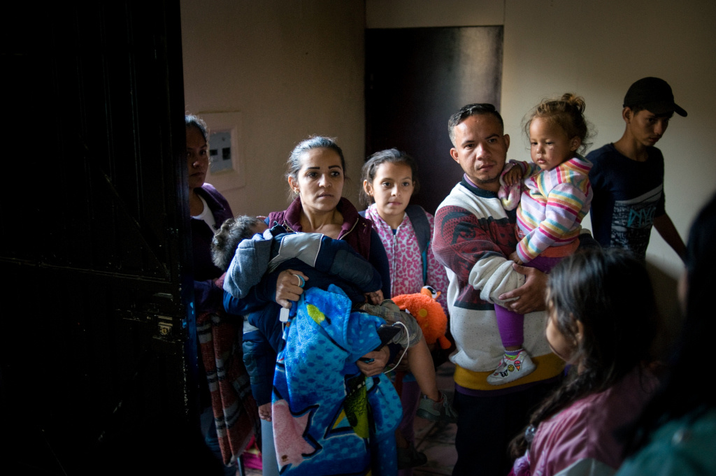 Eine Familie aus Honduras, Vater und Mutter mit zwei kleinen Kindern und einem jugendlichen Mädchen, steht am Eingang einer Flüchtlingsunterkunft der Caritas nahe der Grenze zu den USA in Tijuana. (Foto: KNA)
