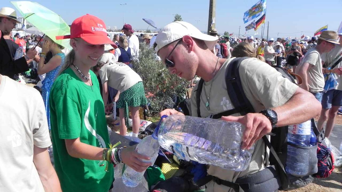 Viel trinken ist wichtig bei den warmen Temperaturen: Ein Pilger verteilt Wasser. (Foto: U. Schwab)